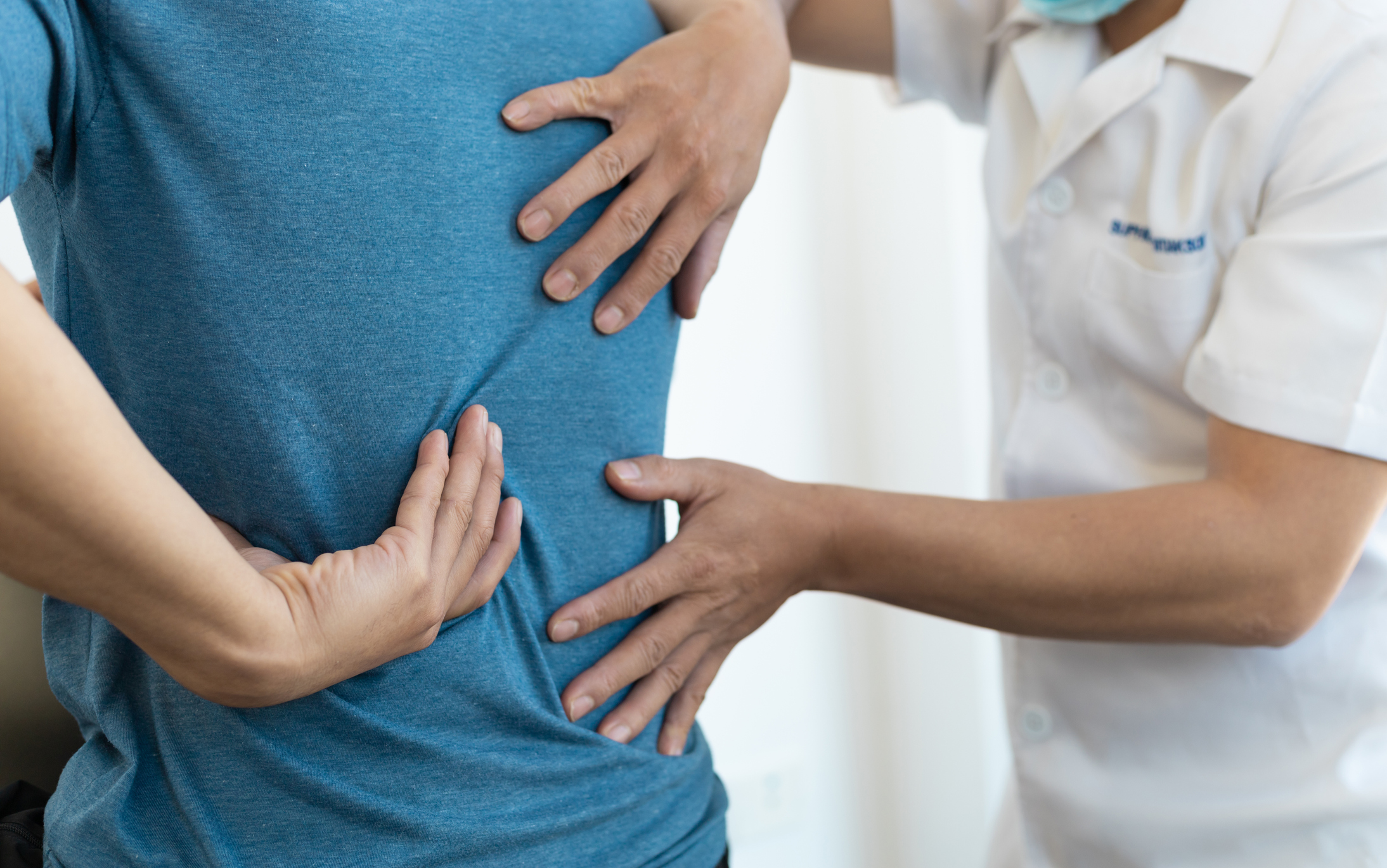 Male back being checked by nurse to observe for pain