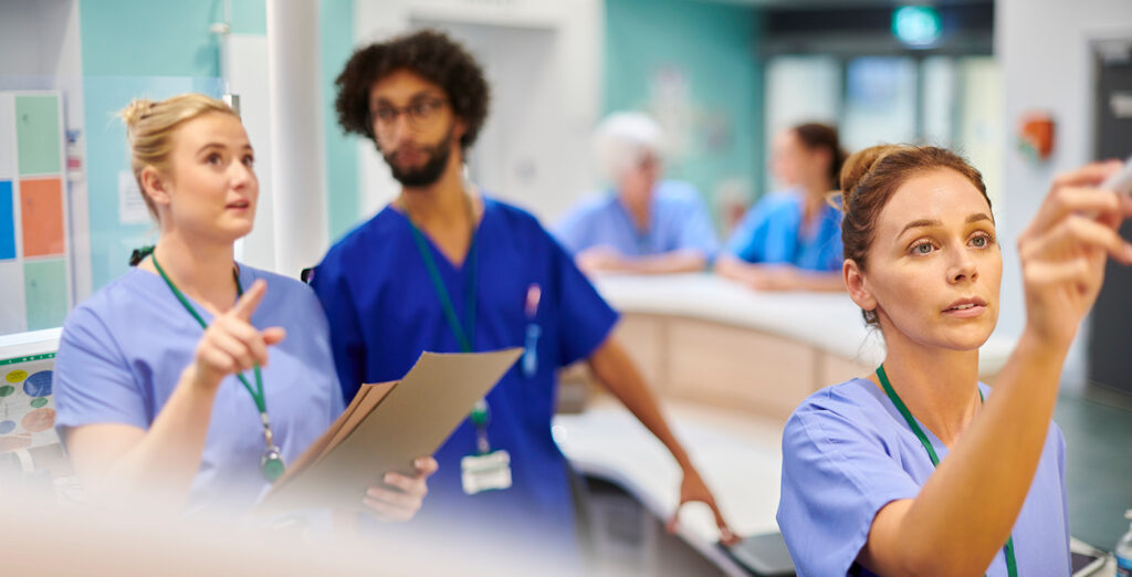Nurses checking board for patient information