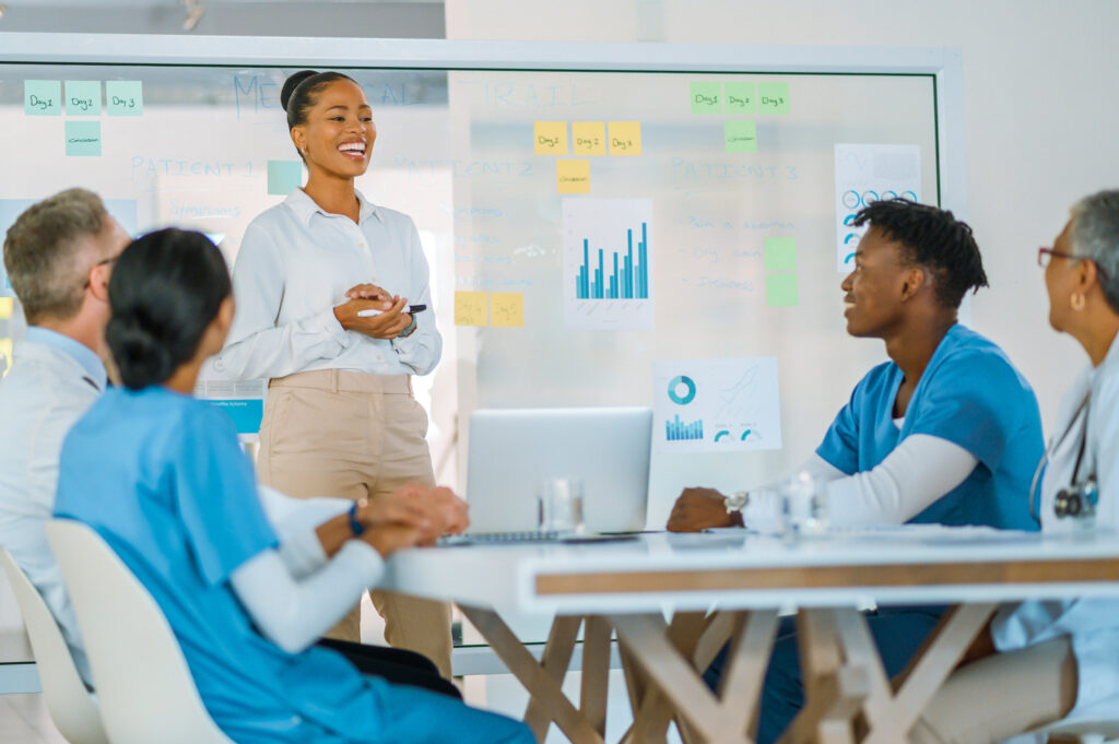 Female business stakeholder representative giving a presentation to doctors in a meeting