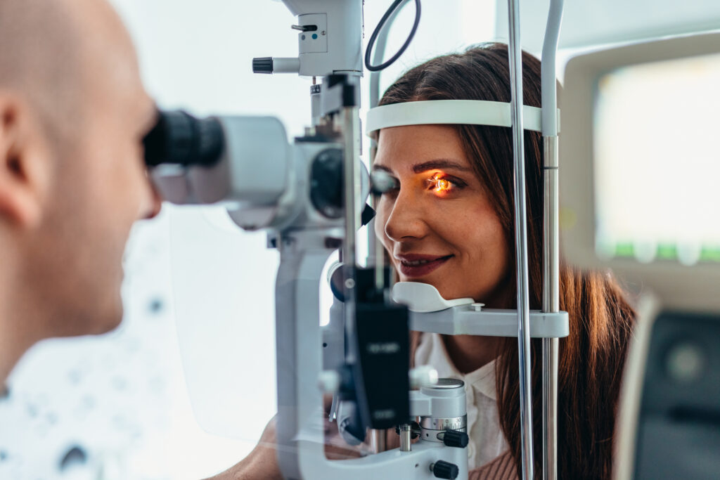 A professional ophthalmologist performing a detailed eye check on patient in a clinical setting.