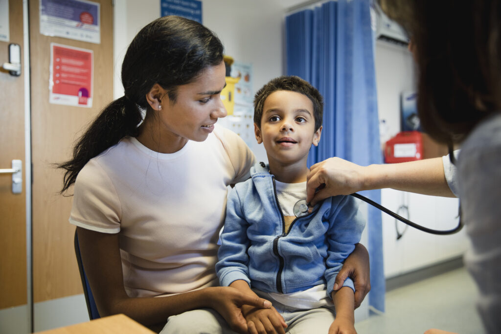 Mother and young son speaking with doctor.